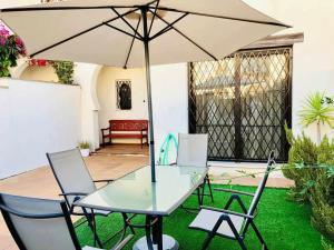 een tafel en stoelen met een parasol in de tuin bij casa jaramar in Sanlúcar de Barrameda