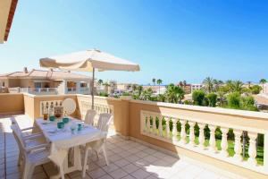 - un balcon avec une table et un parasol dans l'établissement Residencial L'Hort, à Dénia