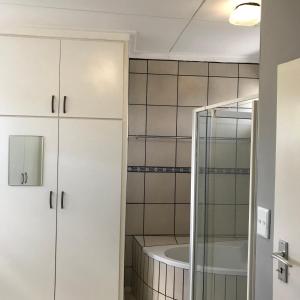 La salle de bains est pourvue d'une douche et d'une baignoire. dans l'établissement Damara Gardens, à Windhoek