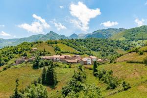 a village on a hill with mountains in the background at Terra Ecoturismo Casa La Casita verde in La Focella
