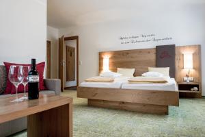 a bedroom with a bed and a bottle of wine at DIE BARBARA Appartements & Zimmer in Schladming