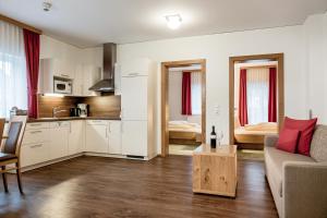 a living room with a couch and a kitchen at Die Barbara Appartements & Zimmer in Schladming