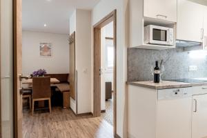 a kitchen and dining room with a table and a microwave at Die Barbara Appartements & Zimmer in Schladming