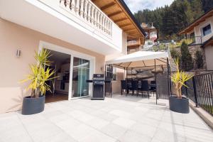 patio z doniczkami i parasolem w obiekcie Chalet Arena w mieście Zell am Ziller