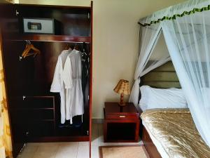 a bedroom with a canopy bed and a closet at AA Lodge Amboseli in Amboseli