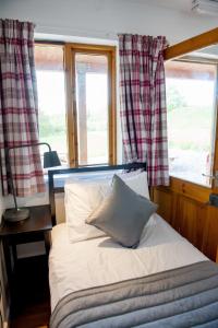 a bed sitting in a room with a window at Cowbridge Cabins in Cowbridge