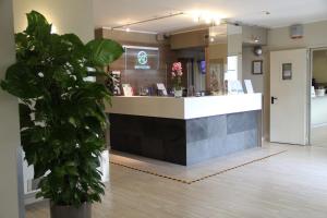 a restaurant with a counter and a potted plant at Green Class Hotel Candiolo in Candiolo