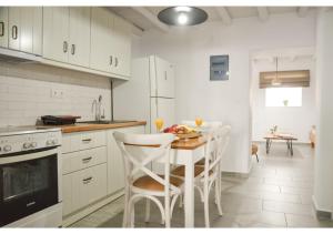 a white kitchen with a table and chairs in it at bougainvillea home at Plaka in Plaka Milou