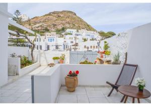 a balcony with a table and chairs and a mountain at bougainvillea home at Plaka in Plaka Milou