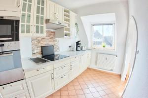 een keuken met witte kasten en een raam bij Fewo Stadtbucht in Eutin