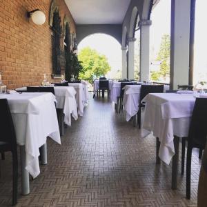 a row of tables in a restaurant with white table cloth at Hotel Ristorante Gallo D'Oro in Vignola +13 photos