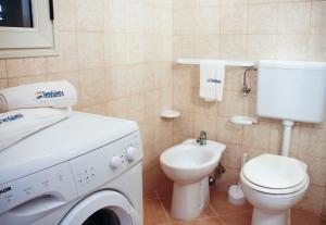 ein Badezimmer mit Waschmaschine und Toilette in der Unterkunft Complesso Giuliano by TerraSalento in Giuliano
