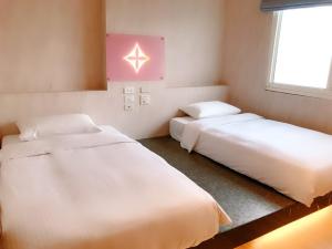 Habitación con 2 camas y ventana en Walker Hotel - Chenggong en Taipéi
