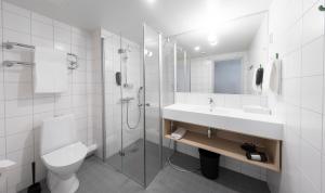 a bathroom with a toilet and a sink and a shower at GreenStar Hotel Lahti in Lahti