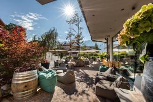 a patio with couches and chairs and plants at Hotel Tirol Fiss in Fiss