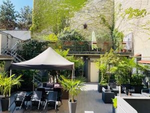 米蘭的住宿－佩魯吉諾酒店，庭院设有椅子和遮阳伞,种有植物