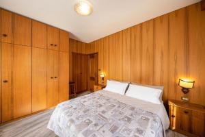 a bedroom with a large bed with wooden walls at Appartamento Primavera 1 in Moena