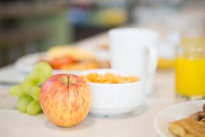 an apple sitting on a table with a plate of food at University of Bath Summer Accommodation in Bath
