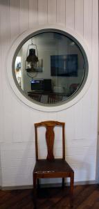 a chair sitting in front of a mirror in a room at Seglarhotellet - Vandrarhem på Käringön in Käringön