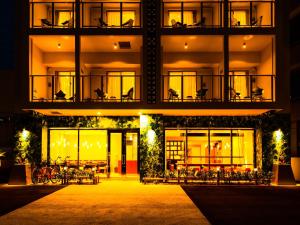 een gebouw met tafels en stoelen er 's nachts voor bij oile by DSH Resorts in Chatan