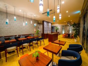 a restaurant with wooden tables and blue chairs at oile by DSH Resorts in Chatan