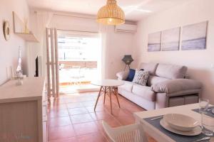 a living room with a couch and a table at Apartamento nuevo junto a la playa vistas al mar in Punta Umbría