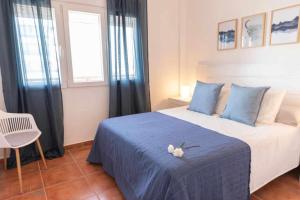 Un dormitorio con una cama azul con un animal de peluche. en Apartamento nuevo junto a la playa vistas al mar en Punta Umbría