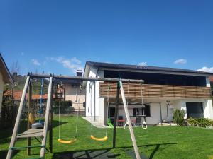 a swing set in a yard in front of a house at Apartment GREEN&URBAN in Celje