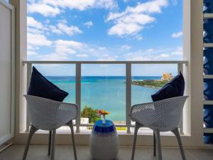 two chairs and a vase in front of a window at oile by DSH Resorts in Chatan