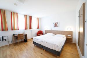 a bedroom with a bed and a desk in a room at Hildegard Forum in Bingen am Rhein