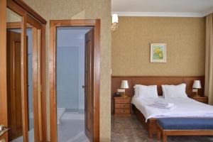 a bedroom with a bed and a bathroom with a tub at Boutique Hotel O. Galogre in Batumi