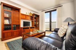 - un salon avec un canapé en cuir et une télévision dans l'établissement La Casa de Lela, à Arrecife