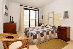 1 dormitorio con 1 cama, 1 silla y 1 ventana en La Casa de Lela, en Arrecife