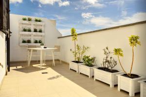 een balkon met potplanten en een tafel erop bij La Casa de Lela in Arrecife