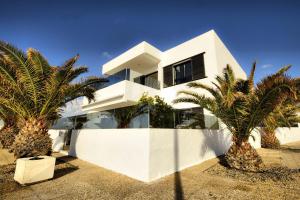 a white house with palm trees in front of it at Casa Botavara in Playa Honda