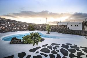 - une piscine en face d'un mur en pierre dans l'établissement Casa Los Olivos, à Mácher