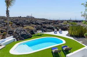 una piscina en un patio con sillas y mesa en Estudio Tegoyo en Mácher