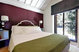 a bedroom with a large bed and a large window at Il mulino di Trastevere - My Extra Home in Rome