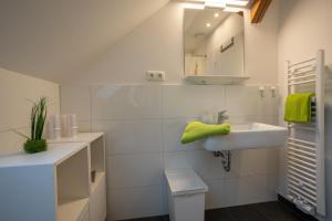 W białej łazience znajduje się umywalka i lustro. w obiekcie Wohnen wie zu Hause w Essen