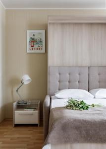 a bedroom with a bed and a table with a lamp at Vertical Aparthotel in Saint Petersburg