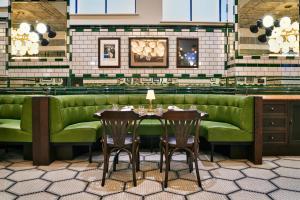 a restaurant with a green couch and two tables at The Grand Hotel Birmingham in Birmingham