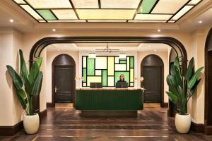 a woman sitting at a reception desk in a lobby at The Grand Hotel Birmingham in Birmingham