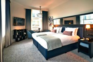 a bedroom with a large bed and a desk at The Grand Hotel Birmingham in Birmingham