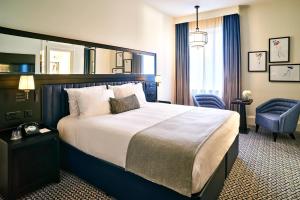 a hotel room with a large bed and a chair at The Grand Hotel Birmingham in Birmingham