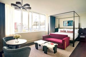 um quarto de hotel com uma cama e um sofá vermelho em The Grand Hotel Birmingham em Birmingham