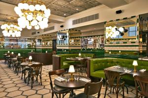 a restaurant with tables and chairs and a green couch at The Grand Hotel Birmingham in Birmingham