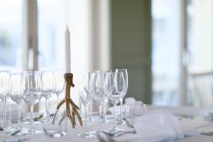 - un groupe de verres à vin sur une table avec une bougie dans l'établissement Arkösunds Hotell, à Arkösund