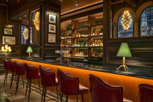 a bar with a row of chairs in a room at The Grand Hotel Birmingham in Birmingham