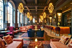 a lobby with couches and tables and a bar at The Grand Hotel Birmingham in Birmingham