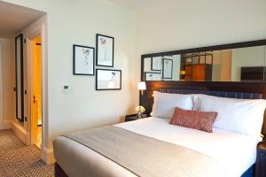 a hotel room with a large bed with white sheets at The Grand Hotel Birmingham in Birmingham